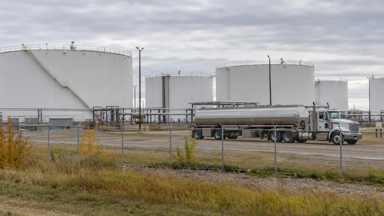 AI-generated illustration of a fuel tanker beside white storage tanks at an Alberta-style distribution terminal